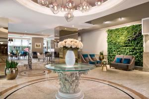 um lobby com um vaso de flores sobre uma mesa em The Westin Zagreb em Zagreb