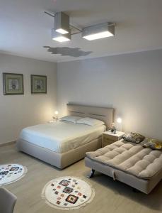 a bedroom with two beds and a couch at Aquamarine Dreams Apartments in Beach of Durres 150 m from Sea in Durrës