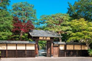 a gate in a park with trees in the background at Suiran, a Luxury Collection Hotel, Kyoto in Kyoto