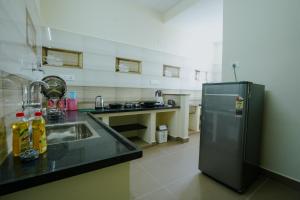 a kitchen with a refrigerator and a sink at Live Inn JP Nagar in Tiruchchirāppalli