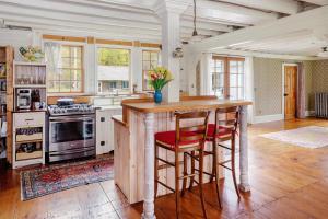 een keuken met een kookeiland met twee krukken bij The Tannery House in Claryville