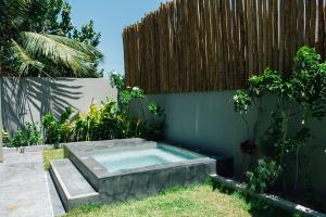 a swimming pool in a garden with a wooden fence at Vila Tuga in Prea