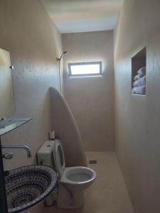 a small bathroom with a toilet and a window at Dar Aya Dmina in Demina