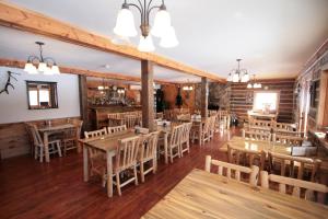 uma sala de jantar com mesas e cadeiras de madeira em Judith Mountain Lodge em Lewistown
