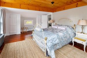 een slaapkamer met een bed en een houten plafond bij The Tannery House in Claryville