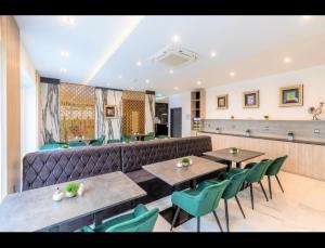 a restaurant with two tables and green chairs at Hotel Business Bay das ehemalige Staycation Hotel in Sindelfingen