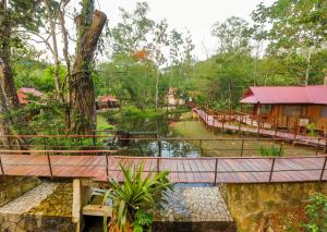 un puente sobre un río en un bosque en Cabañas Kin Balam Palenque, en Palenque