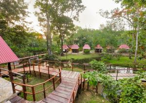 a wooden walkway leading to a group of huts at Cabañas Kin Balam Palenque in Palenque