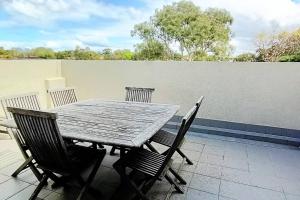 einen Holztisch und Stühle auf einer Terrasse in der Unterkunft Location and Lifestyle - 1 bed, 2 bath + parking in Sydney