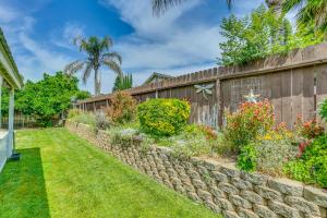 einen Garten mit einer Mauer und Blumen in der Unterkunft Peaceful Fresno Home, Near Popular Wineries! in Fresno