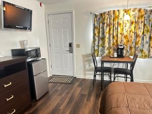 a small room with a bed and a table with chairs at Blue Spruce Inn & Townhouses in Plymouth