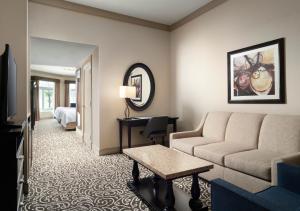 a hotel room with a couch and a bed at West Inn & Suites in Carlsbad