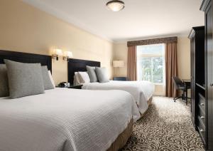 a hotel room with two beds and a window at West Inn & Suites in Carlsbad