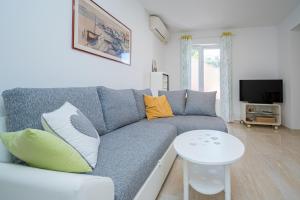 a living room with a blue couch and a table at Apartments by the sea Sali, Dugi otok - 19880 in Sali