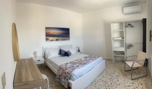a white bedroom with a bed and a desk at Appartamento SOLE in Villa Giulia sul Mare in Marausa