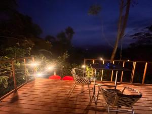 a deck with chairs and lights at night at Cabaña Los Cedros in La Vega