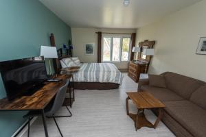 a living room with a couch and a bed at Auberge Beausejour in Les Éboulements