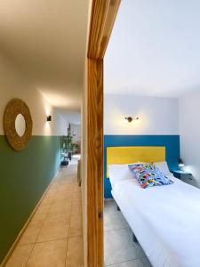 1 dormitorio con 1 cama blanca y paredes verdes y azules en Único Piso Colorido y Divertido En Ransol - Increibles Vistas al Rio y Naturaleza - Ideal Familias en Andorra la Vella