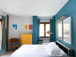 安道爾城的住宿－Único Piso Colorido y Divertido En Ransol - Increibles Vistas al Rio y Naturaleza - Ideal Familias，一间卧室配有一张带蓝色墙壁的大床