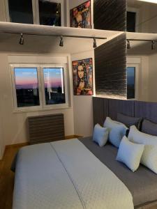 a bedroom with a bed and three windows at PAUZA apartman in Novi Sad