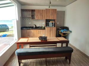 a table with a bench in a kitchen with a microwave at Finca La Piedra in Aquitania