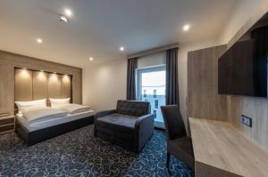 une chambre d'hôtel avec un lit et une chaise dans l'établissement Hotel Business Bay das ehemalige Staycation Hotel, à Sindelfingen