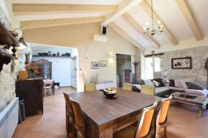 a kitchen and living room with a wooden table and chairs at Luxury Casa Nini w fireplace and private pool in Poreč