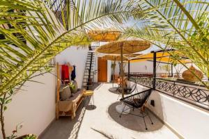 Habitación con balcón con sofá y palmera en Riad Olika, en Marrakech
