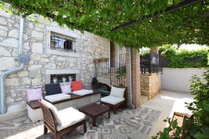 a patio with tables and chairs and a stone building at Luxury Casa Nini w fireplace and private pool in Poreč
