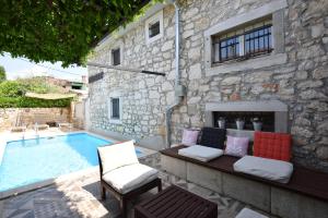 a patio with a swimming pool next to a stone building at Luxury VILLA NINI with private pool, bikes, barbecue and much more in Poreč