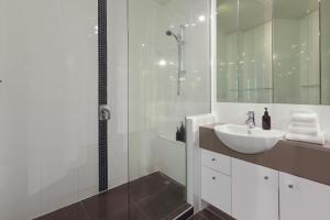 un bagno bianco con lavandino e doccia di The Cove Noosa - Apartment 20 a Noosa Heads Altre 2 foto
