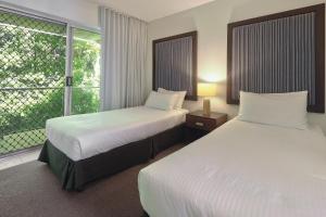 una camera d'albergo con due letti e una finestra di The Cove Noosa - Apartment 20 a Noosa Heads
