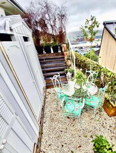 a small backyard with chairs and a table and stairs at Glamping in Luxury at Little Lytelton Boatique House in  Lyttelton