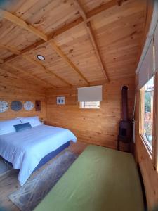 a bedroom with a bed in a wooden cabin at El Refugio del Santo 