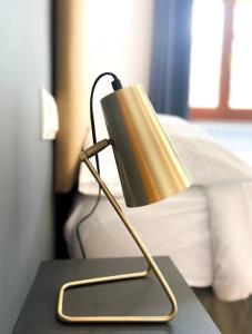 uma lâmpada sobre uma mesa ao lado de uma cama em Moderno Y Rústico En Ransol 6pax em Canillo