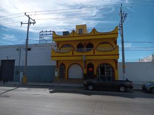 a truck parked in front of a yellow building at Hotel Kiko in Mazatlán