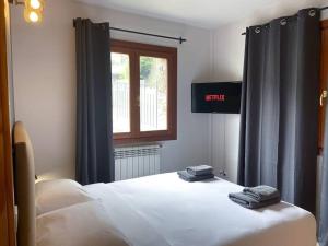 a bedroom with a bed with two towels on it at Moderno Y Rústico En Ransol 6pax in Canillo