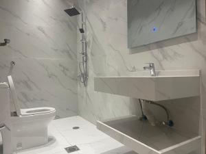 La salle de bains blanche est pourvue d'un lavabo et de toilettes. dans l'établissement فلل بيات الفيصل Bayat Al Faisal Villas, à Baljurashi