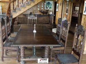 a wooden table and chairs in a room at Mansão rústica Medieval Luxo Santuário Bellatrix in Campo Novo