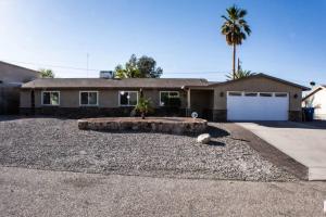 a house with a gravel yard in front of a driveway at Good vibes, amazing backyard, plenty of parking in Lake Havasu City