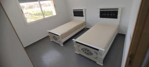 um quarto com duas camas e uma janela em Logement familial em Selouane