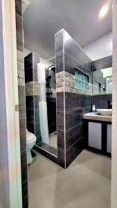 a bathroom with a shower and a toilet and a sink at Hidden Palms Inn in san juan la union