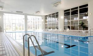 ein großer Pool mit blauem Wasser in einem Gebäude in der Unterkunft Blue Ridge Hotel in Toyooka