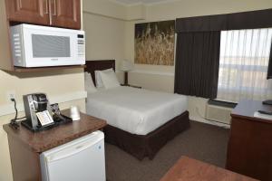 a hotel room with a bed and a microwave at Days Inn by Wyndham Lamont in Lamont