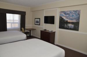 a hotel room with two beds and a desk at Days Inn by Wyndham Lamont in Lamont