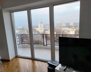 a room with a large window with a view of a city at Mr.-Legend's Penthouse in Skopje