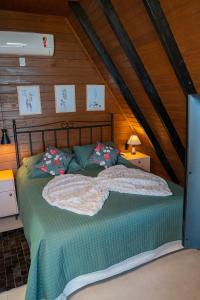 1 dormitorio con 1 cama con sábanas y almohadas verdes en Caminhos da Esmeralda, en Urubici