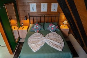 Una cama con una manta y almohadas encima en Caminhos da Esmeralda, en Urubici