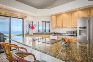 a kitchen with a counter top with a refrigerator at Oceanview Luxury Villa Pool & SPA in Kailua-Kona