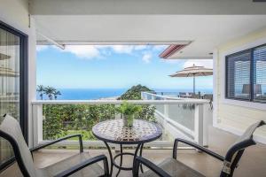 una mesa y sillas en un balcón con vistas al océano en Oceanview Luxury Villa Pool & SPA, en Kailua-Kona